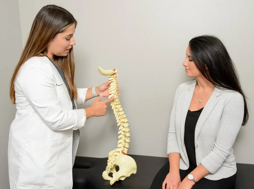 a physician showing a patient a diagram of a spine