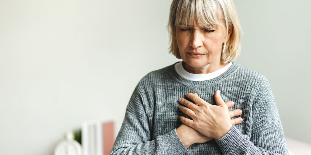 a woman grabbing her chest in pain