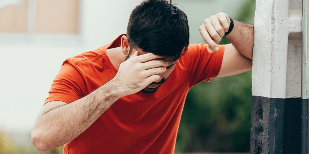 a man grabbing his forehead in pain